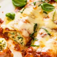 Cannelloni · Rolled pasta with ricotta cheese, beef, spinach topped in marinara, and mozzarella cheese on...