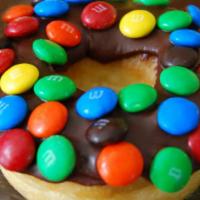 M & M · Donut with chocolate icing and M & M on top.