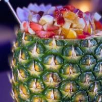 Fresh Hawaiian Tropical Pineapple Cup · Fruit salad on top of fruit cocktail juice in a big carved pineapple.