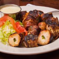 Togo Loaded Pollo Bullets · Chicken stuffed with Cream Cheese and Jalapeños, wrapped in Bacon and served with Cajun Crea...