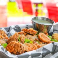 Boudin Chips · Sliced spicy boudin lightly dusted in flour & fried until crispy. Finished w/ Cajun dust & g...