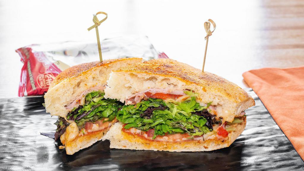 The Italian Sandwich · Hardwood Smoked Ham, Pepperoni and Italian Cheese Blend with Tomato, Grated Parmesan, Lettuce Mix and Pesto Aioli on Fresh Baked Ciabatta Bread 720 calories.