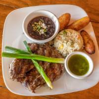 Carne Asada · Marinated skirt steak served with rice, black beans, and side of chimichurri. Topped with gr...