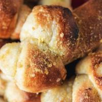 Garlic Knots · Eight garlic knots, drizzled with olive oil and garlic. Comes with one container of red sauce.