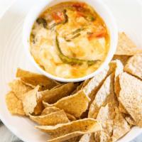 Chile Con Queso · Smooth & mellow queso blanco melted & spiked with tomatoes, onions & poblano chiles.