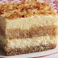 Postre De Coco · Tiered buttermilk white cake with a cream cheese frosting, toasted coconut & our homemade pe...
