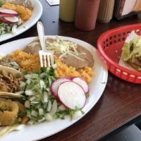 Taco Plate With Flour Tortillas · Three tacos rice and beans.