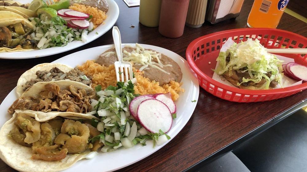 Taco Plate With Flour Tortillas · Three tacos rice and beans.