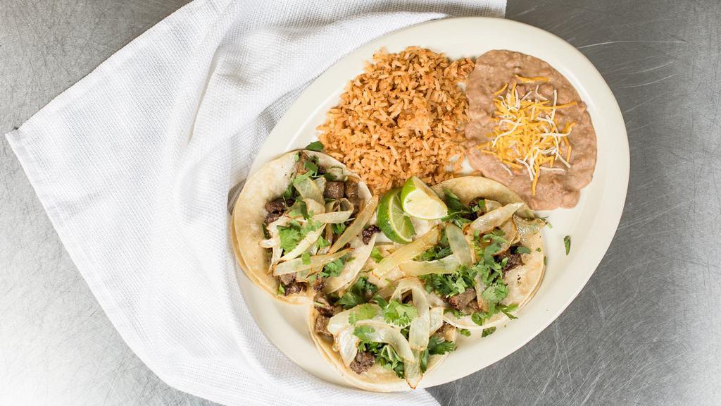 Tacos Juan · Three street style tacos with your choice of meat, topped with onion and cilantro. Comes with your choice of refried or charro beans and rice.