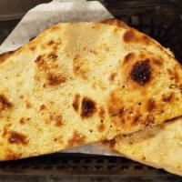 Kandhari Naan · Thinly stretched dough cooked in a fiery clay oven, topped with butter and toasted sesame se...