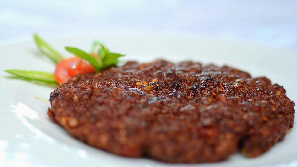 Chappli Kabobs (2 Patties) · Flattened ground beef patties cooked over a bed of thinly sliced onions, green peppers, tomatoes and dusted with light spices.