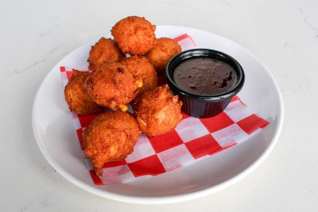 Hush Puppy Corn Fritters · Deep fried cornbread nuggets with fresh jalapeños and yellow corn. Served golden brown with our sweet jalapeño jam.