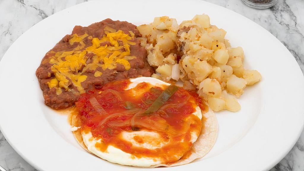 Huevos Rancheros · 2 eggs over medium, ranchero sauce, potatoes, and refried beans. Served with choice of side and flour tortillas.