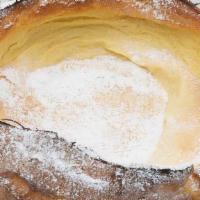 Dutch Baby Pancake · Oven baked to golden perfection. Served with whipped butter, lemon, and powdered sugar.