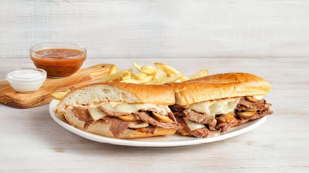 Prime Rib Sandwich · Tender slow-roasted prime rib, grilled onions and mushrooms, Provolone cheese, and our spicy signature bloom sauce on a toasted baguette. Served with a side of French onion au jus, creamy horseradish sauce and one freshly made side. Based on availability