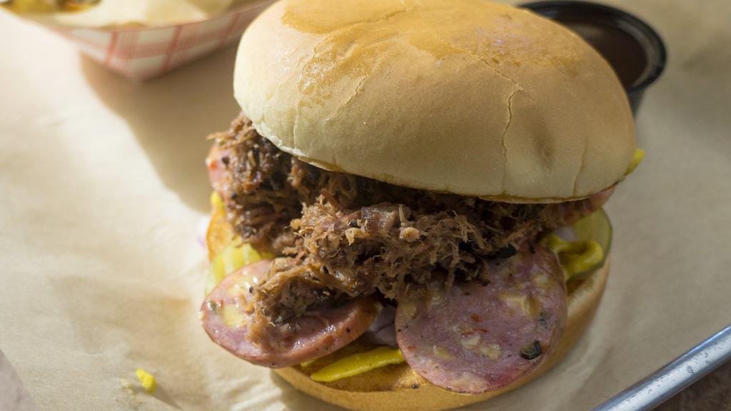 The Deadbeat · Chopped brisket, jalapeno sausage, mustard, pickles, onions, and barbecue sauce on a toasted bun.