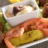Falafel Sandwich · Fried chickpea fritters wrapped in pita bread, and filled with hummus, tomatoes, and pickles
