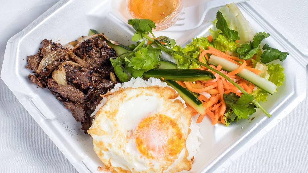 Rice Box (Cơm) · White rice topped with a fried egg and your choice of protein (chicken, grilled BBQ pork [thit nuong], beef, or Vietnamese meatballs [xiu mai]). Served with a bed of lettuce topped with pickled carrots, cucumbers, jalapenos, and cilantro, and a side of fish sauce (nuoc mam).