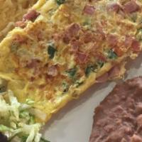 Mexican Omelette · Omelette with tomato, onions , peppers, diced ham served with hash browns and beans.
