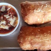 Kids Pepperoni Rolls Togo · Two pepperoni rolls with a side of marinara dipping sauce.