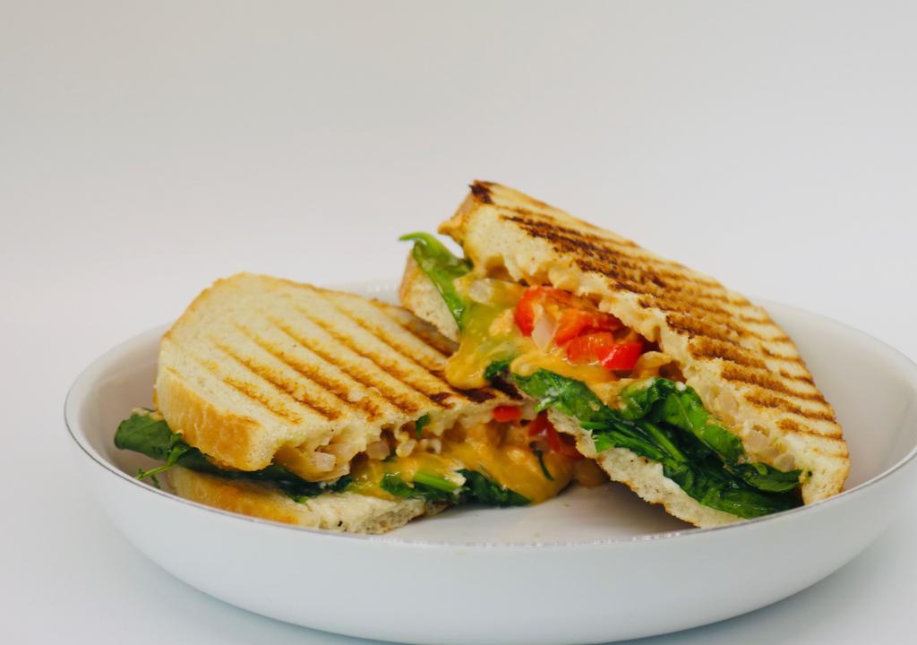 Ryg Panini · (Red, Yellow, and Green vegetables). Roasted red peppers, arugula, spinach, melted Gouda cheese, red onions, and a red pepper hummus sauce.