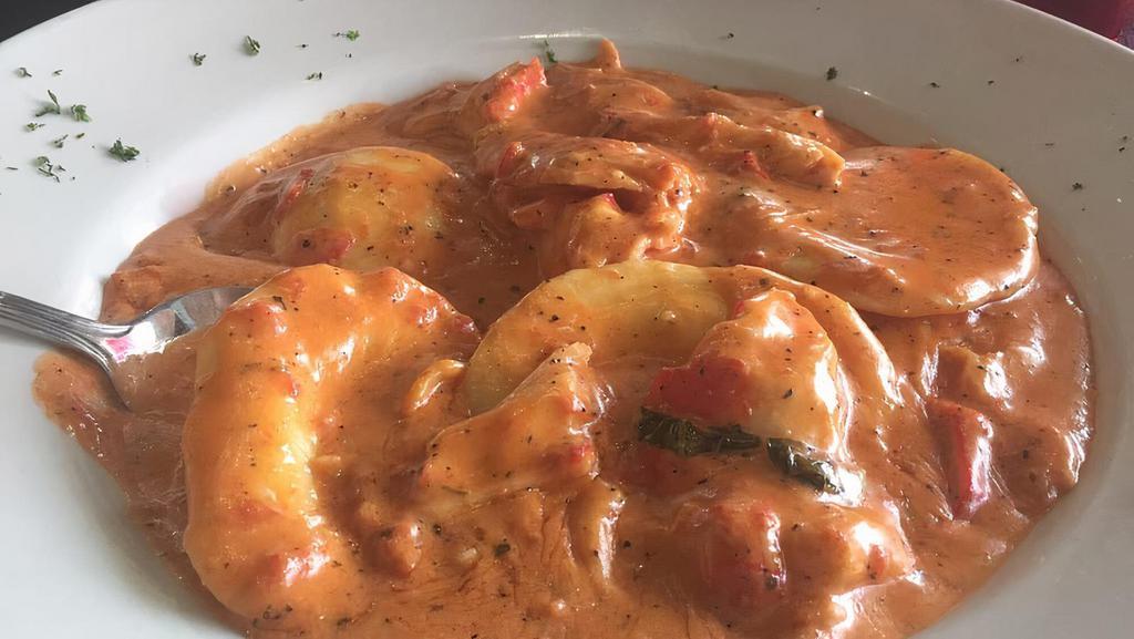 Lobster Ravioli · Four lobster filled ravioli in a pink sauce.