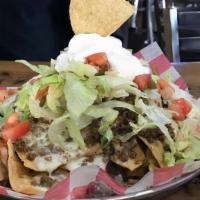 Big Ol' Nachos · A mountain of tortilla chips, topped with ground beef or fajita chicken,  2 layers of queso,...