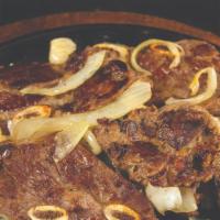 Tablitas · Thinly sliced beef ribs topped on a sizzling comal with grilled onions and bell peppers. Ser...