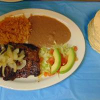 Carne Asada (Arrachera) · A marinated beef skirt steak topped with grilled onions and peppers, Served with beans, rice...