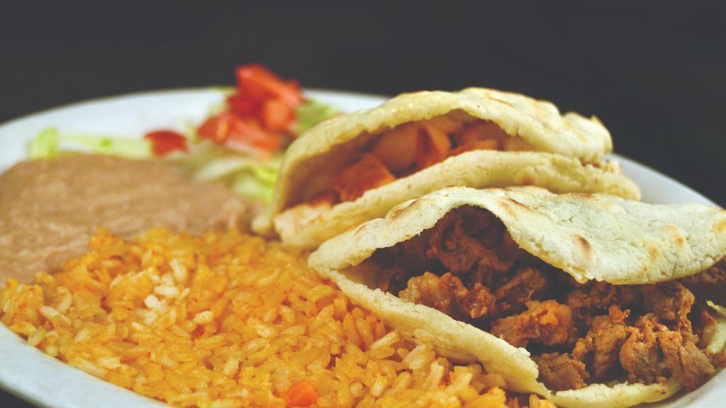 Gorditas · Two gorditas (corn patties) filled with ground beef or chicken served with refried beans and rice.