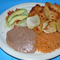 Milanesa · A lightly breaded, thin sliced tender steak topped with sliced potatoes served with refried ...