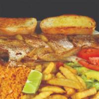 Pescado Frito · A seasoned catfish, deep fried served with rice, avocado slices, and salad.