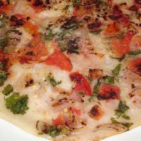 Tomato Uthappam · Thick rice and lentil pancake topped with tomatoes.