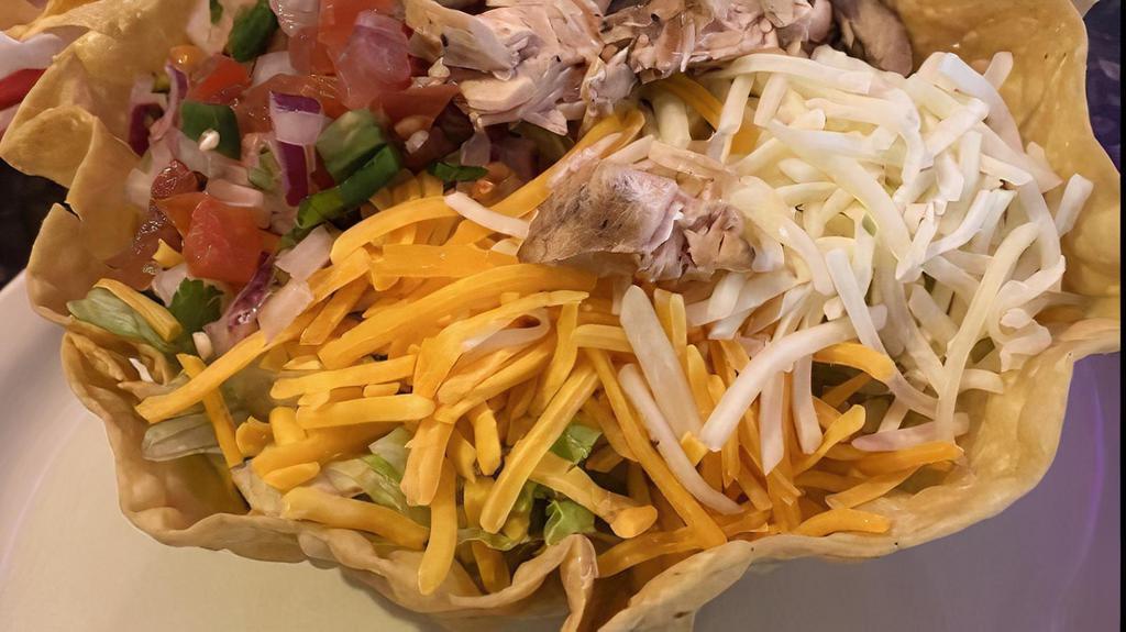 Taco Salad · With choice of ground beef or shredded chicken fajita inside tortilla shell filled with beans, lettuce, pico de gallo, cheese, guacamole, and sour cream.