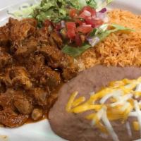 Guiso De Puerco · Pork stew cooked with red sauce served with rice, beans, pico de gallo, lettuce and choice o...