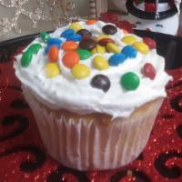 M&M'S Cupcake  · Vanilla Cupcake with butter cream icing sprinkled with  M& M's candy.