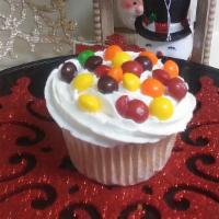 Skittles Cupcake · Vanilla cupcake with white butter cream icing sprinkled with Skittles on top.