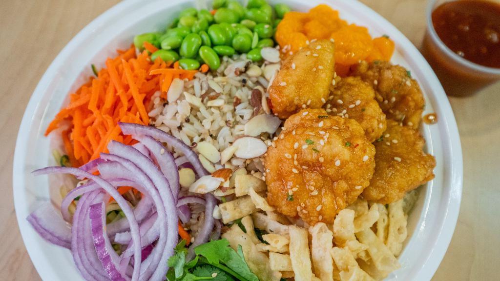 Asian Grain Bowl · Zoodles, cabbage mix, wild rice blend, quinoa, shredded carrots, red onions, cilantro, mandarin oranges, edamame, wontons, almonds and sesame Sriracha dressing.