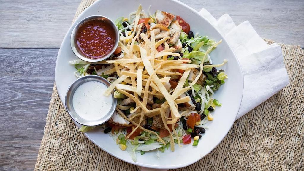 Grilled Chicken Taco Salad · Seasoned grilled chicken, black bean and corn pico, diced tomatoes, sour cream, and avocado on mixed greens with shredded lettuce.  Topped with seasoned tortilla strips and chives.  Served with a side of salsa and ranch