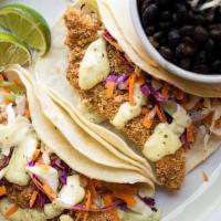Crispy Catfish Tacos · Two tacos filled with our Texas Tortilla Catfish and shredded cabbage & carrots topped with ...