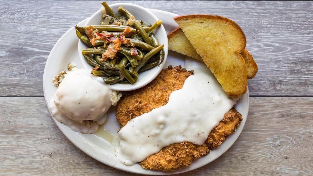 Chicken Fried Steak · The culinary staple of the Lone Star State. Tender steak seasoned and fried in our signature Shiner Bock buttermilk batter, then smothered in peppered cream gravy, served with Texas toast and two sides.  May we recommend mashed potatoes and gravy & bacon-braised green beans?
