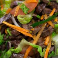 Yum Nhua - Beef Salad · Fresh mixed greens, romaine lettuce, cucumber, cilantro, tomatoes, jalapeños, red onions, an...