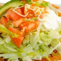 Taco Salad · Mixed greens, taco meat, pico, sour cream, salsa, mixed cheese. Garnished with Doritos.