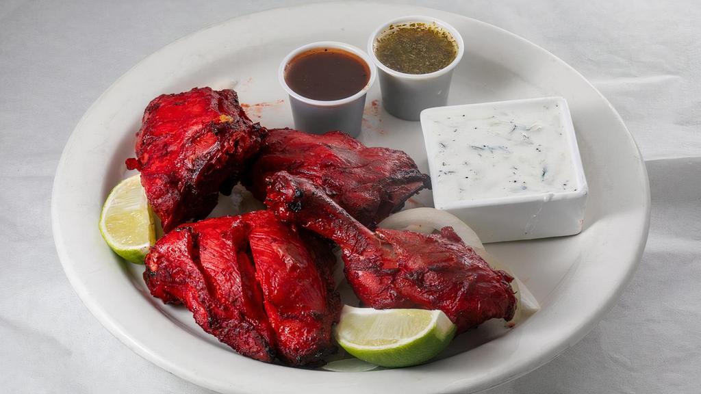 Tandoori Chicken · Chicken leg quarters marinated in fresh spices, herbs, yogurt, and barbecued over flaming charcoal in the tandoor. Served with rice.