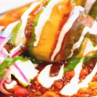 Samosa Chaat · Fried pastry stuffed with spiced potatoes topped with onions, chickpeas, yogurt, & chutneys.