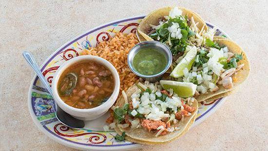 Street Taco · Three corn or flour tortillas with brisket, chicken, beef or al pastor (pork), served “Street Style” with diced onions, chopped cilantro, cheese and lime. Served with Mexican rice and Charro beans.