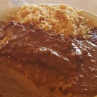 Enchiladas Poblanas · Two chicken enchiladas topped with mole sauce served with rice, beans, and sour cream.