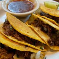 Birria Tacos · Slow cooked beef tenderloin in adobo sauce, onion, and cilantro served with a side of beef c...