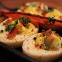 Deviled Eggs And Bacon · Six deviled eggs dusted with our signature house seasoning then topped with diced bacon and ...