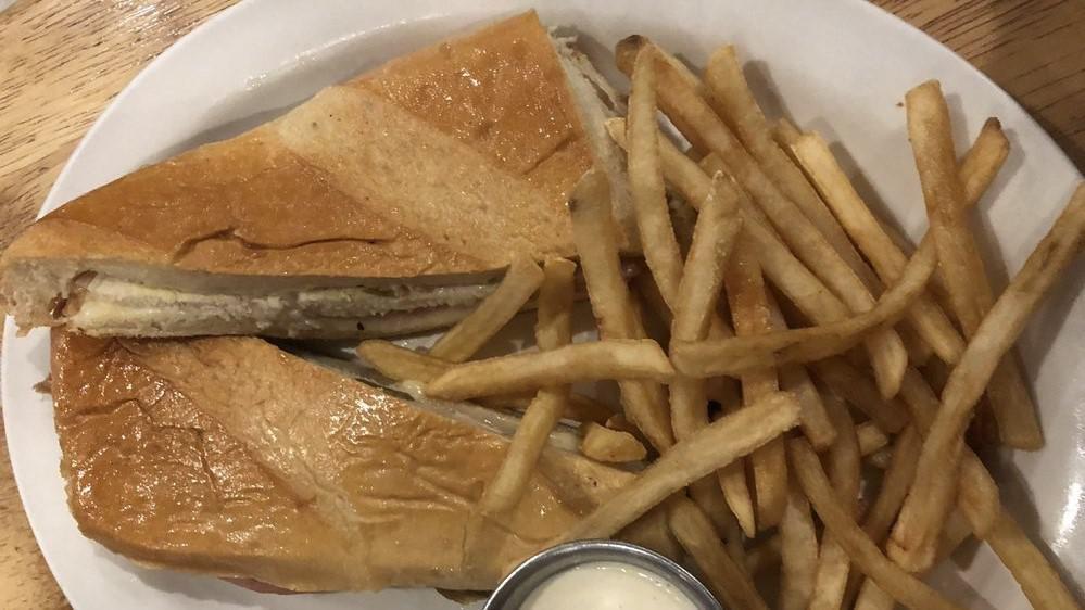 Cuban Sandwich · French bread, sliced pork, ham, Swiss cheese, pickles, Cuban mojo and mayonnaise or mustard. Served with fried plantains and your choice of black beans and rice mixed together or rice and beans served apart.
